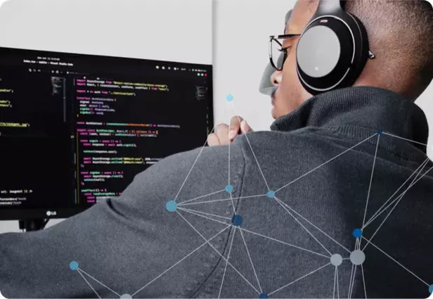 A picture of a developer working in front of a computer screen full of code